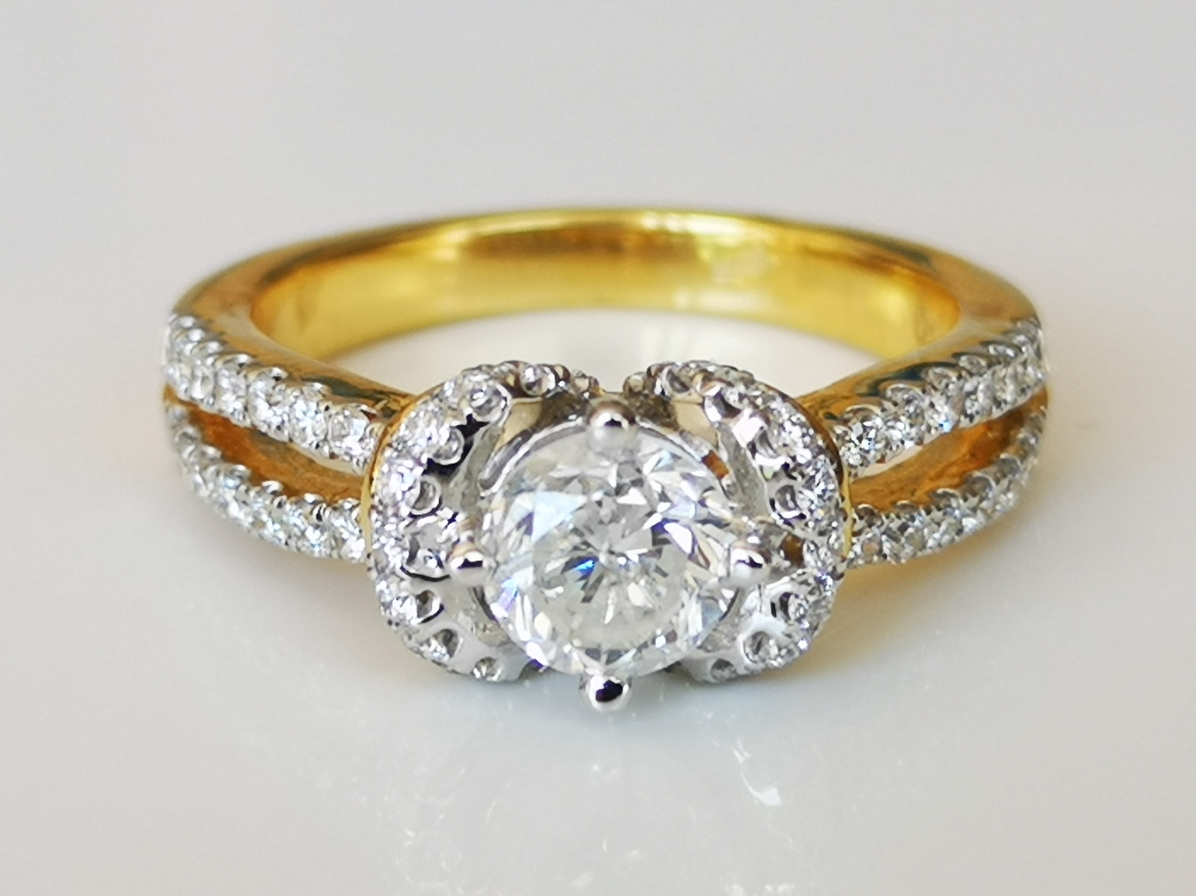 Bague en or 18 carats diamants central de 0.77 ct et entourage de diamants Bijoux et montres