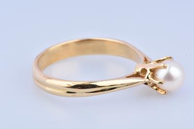 Bague solitaire en or (750 millièmes), ornée d’1 perle de culture blanche env. 0.5cm sertie de 6 griffes. 2