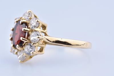 18-carat gold ring composed of an oval garnet set with 8 prongs and 8 shiny oxides 2