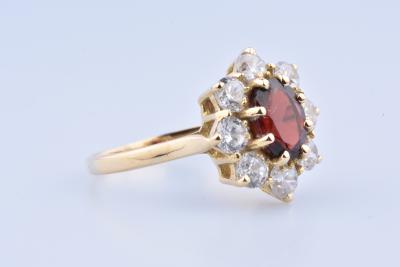 18-carat gold ring composed of an oval garnet set with 8 prongs and 8 shiny oxides 2