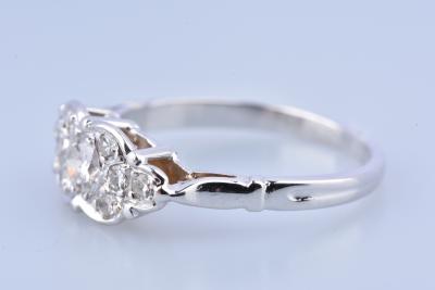 Bague en or blanc , le chaton écusson serti d'un diamant principal épaulé de 8 petits diamant 2
