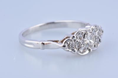 Bague en or blanc , le chaton écusson serti d'un diamant principal épaulé de 8 petits diamant 2